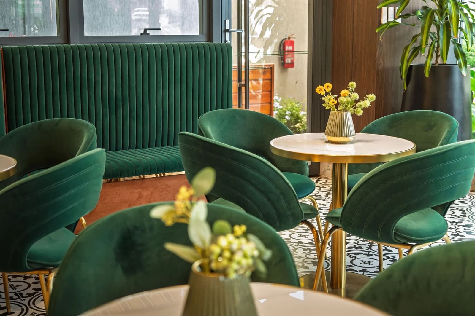 ESP Hotel lounge with green velvet chairs and brass tables